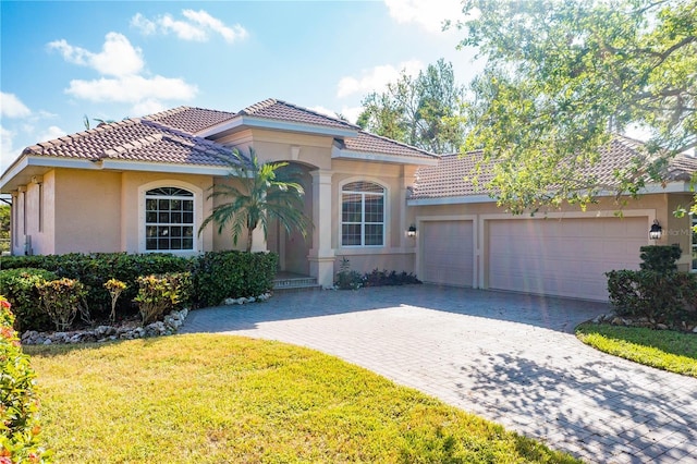 mediterranean / spanish-style home with a front yard and a garage