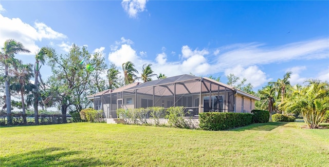 back of house featuring a yard and glass enclosure