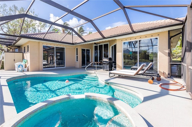 view of swimming pool featuring a lanai, ceiling fan, a patio area, and an in ground hot tub