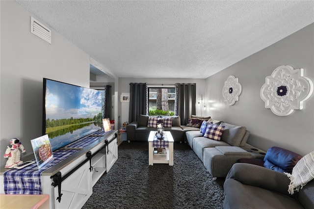 living room featuring dark colored carpet and a textured ceiling