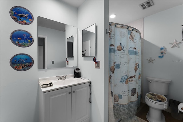 bathroom with walk in shower, vanity, and toilet