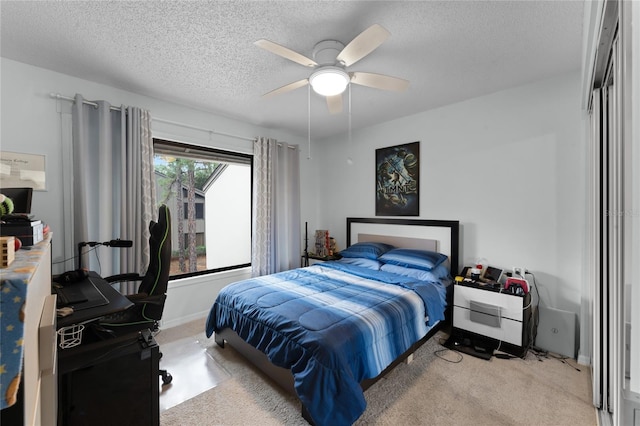 carpeted bedroom featuring a textured ceiling and ceiling fan