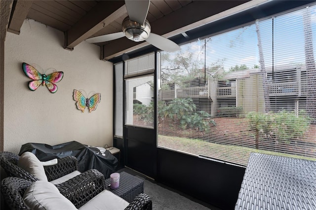 sunroom featuring ceiling fan and beam ceiling