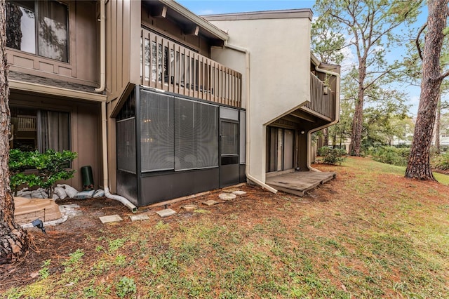 exterior space featuring a lawn and a balcony