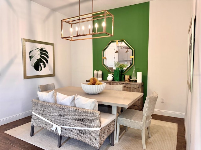 dining area with dark hardwood / wood-style flooring and an inviting chandelier