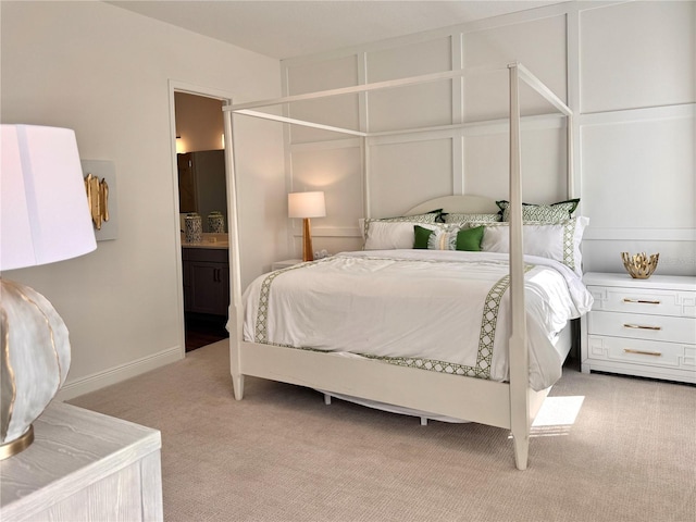 bedroom with light colored carpet and ensuite bath