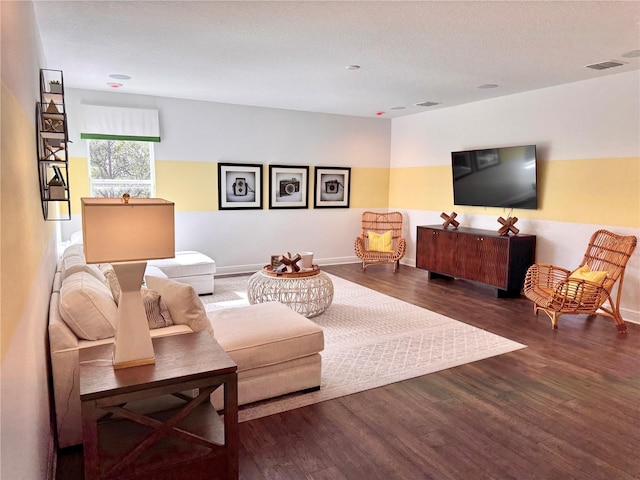 living room with a textured ceiling and dark wood-type flooring