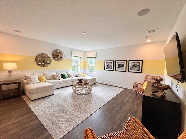 living room featuring wood-type flooring and a textured ceiling