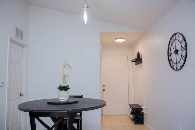 tiled dining space featuring vaulted ceiling