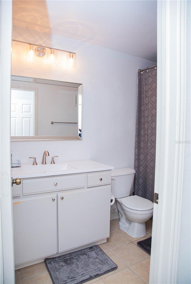 bathroom with tile patterned floors, vanity, toilet, and walk in shower