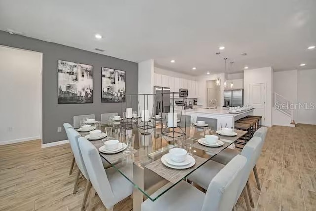 dining room with light wood-type flooring and sink