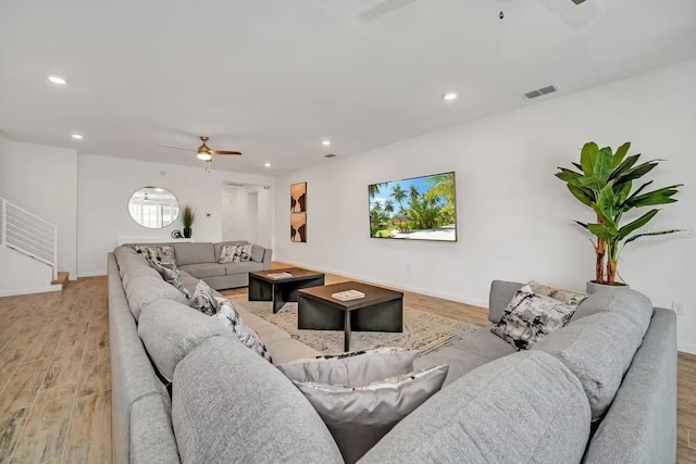 living room with light hardwood / wood-style flooring and ceiling fan