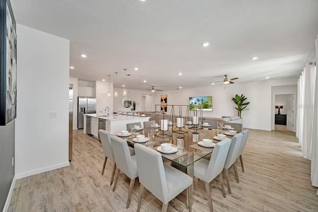 dining room featuring light hardwood / wood-style floors, ceiling fan, and sink