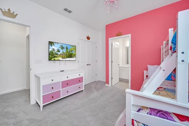 bedroom featuring ensuite bathroom and light colored carpet