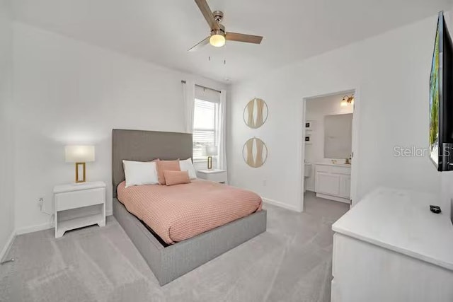 bedroom featuring light carpet, connected bathroom, and ceiling fan