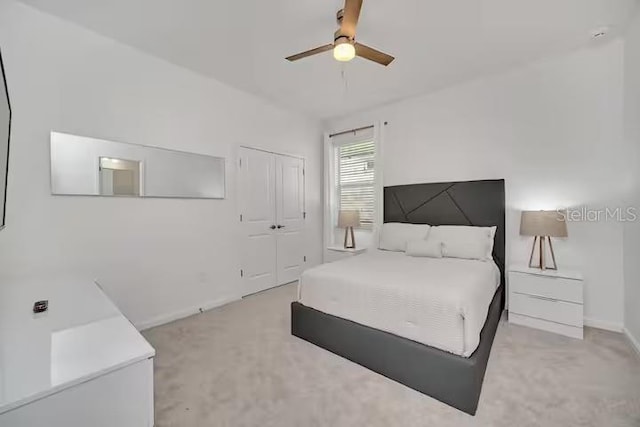 bedroom featuring light carpet, a closet, and ceiling fan