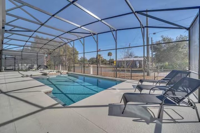 view of swimming pool with glass enclosure and a patio area