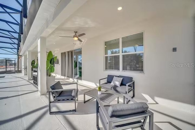 view of patio / terrace with outdoor lounge area, ceiling fan, and glass enclosure