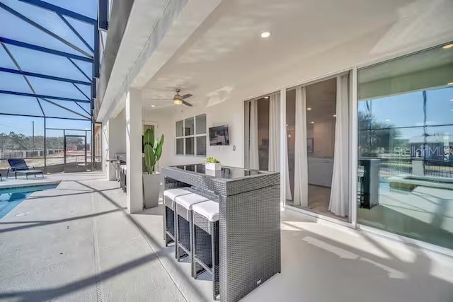 view of patio / terrace featuring glass enclosure and ceiling fan