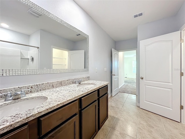 bathroom with tile patterned floors, vanity, and walk in shower