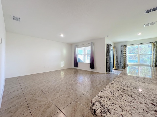 tiled empty room featuring a healthy amount of sunlight