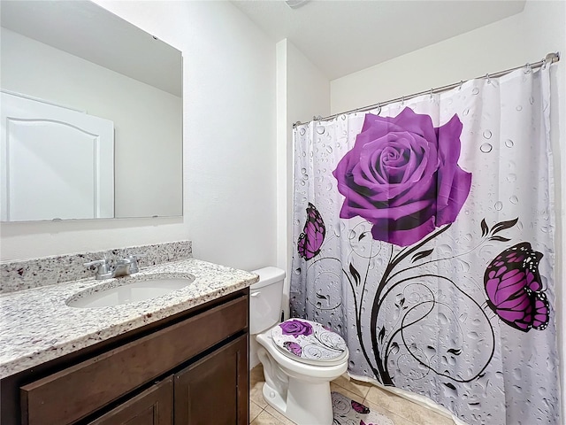 bathroom with tile patterned flooring, vanity, and toilet