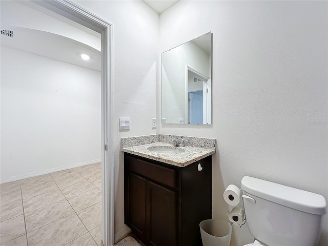 bathroom with tile patterned flooring, vanity, and toilet