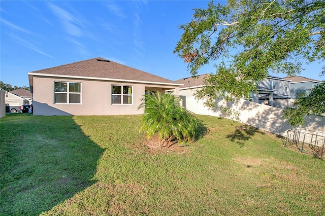 rear view of property with a lawn