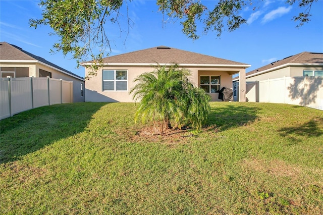 rear view of property with a lawn