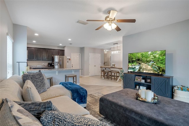 living room featuring ceiling fan and light hardwood / wood-style floors