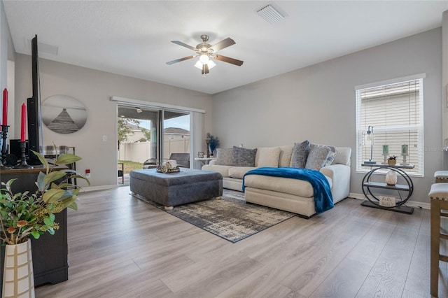 living room featuring ceiling fan and light hardwood / wood-style floors