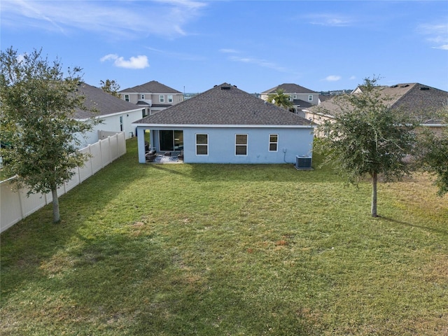 back of house featuring central AC and a lawn