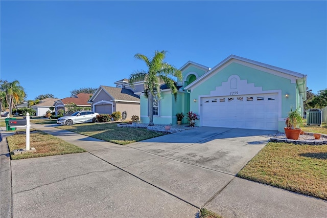 ranch-style house with a garage, a front yard, and central AC unit