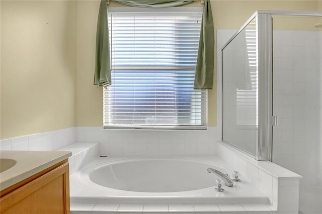 bathroom with vanity and shower with separate bathtub