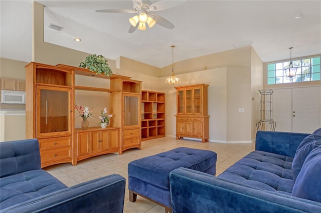 tiled living room featuring ceiling fan with notable chandelier