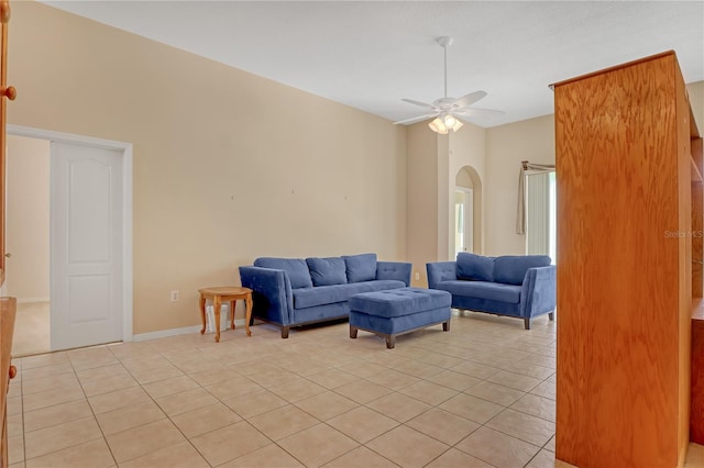 tiled living room with ceiling fan and vaulted ceiling