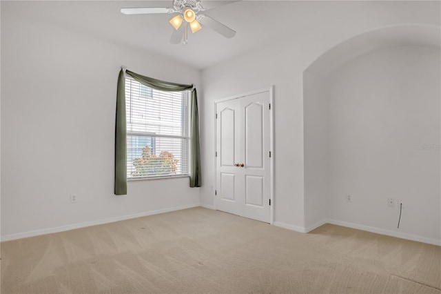 carpeted spare room with ceiling fan