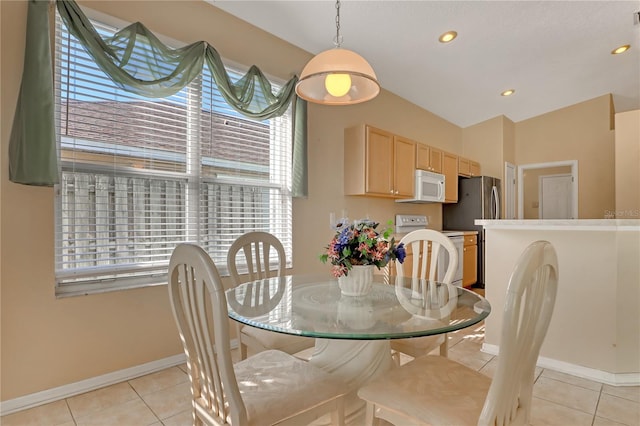 tiled dining space with lofted ceiling