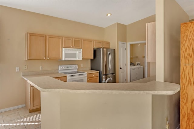 kitchen featuring white appliances, washing machine and dryer, light tile patterned flooring, light brown cabinetry, and kitchen peninsula