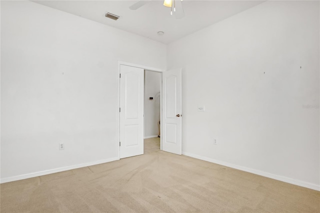 empty room featuring light colored carpet and ceiling fan