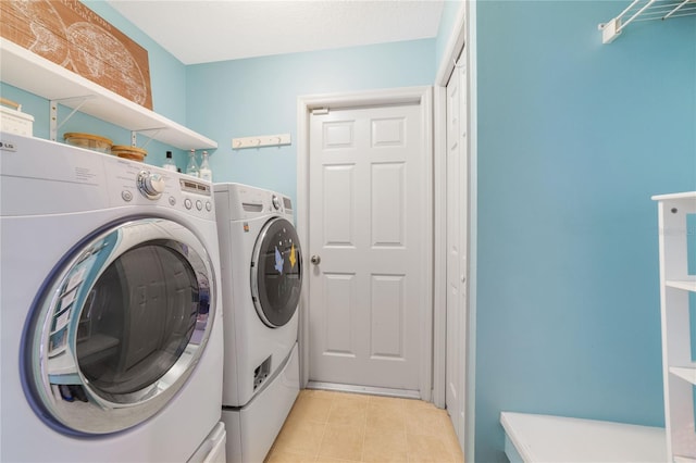 laundry area featuring washer and clothes dryer and light tile patterned floors