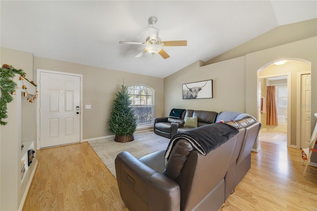 living room featuring ceiling fan, light hardwood / wood-style flooring, and vaulted ceiling