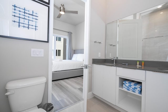 bathroom featuring ceiling fan, vanity, wood-type flooring, and toilet