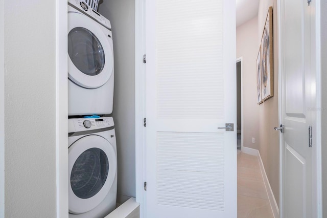 washroom featuring light tile patterned floors and stacked washer and clothes dryer