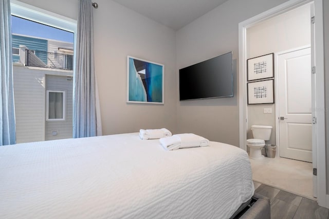 bedroom featuring wood-type flooring and ensuite bathroom