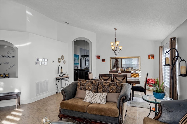 tiled living room with vaulted ceiling, a chandelier, and a textured ceiling