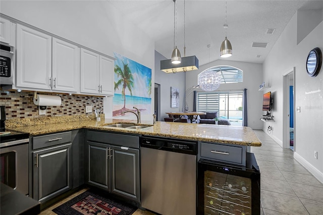 kitchen featuring white cabinets, stainless steel appliances, kitchen peninsula, and sink