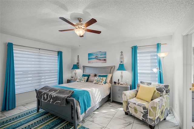 bedroom with ceiling fan and a textured ceiling