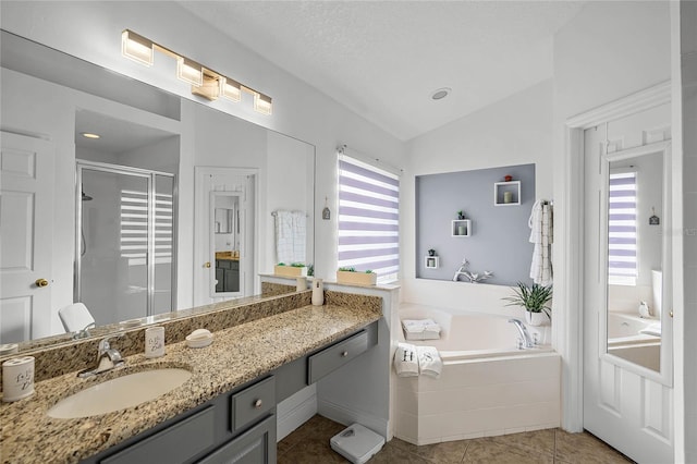 bathroom featuring tile patterned floors, a textured ceiling, vanity, separate shower and tub, and lofted ceiling