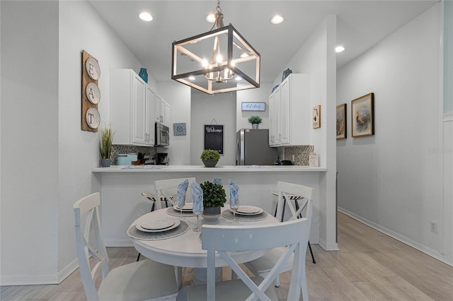 dining area featuring light hardwood / wood-style flooring and a chandelier